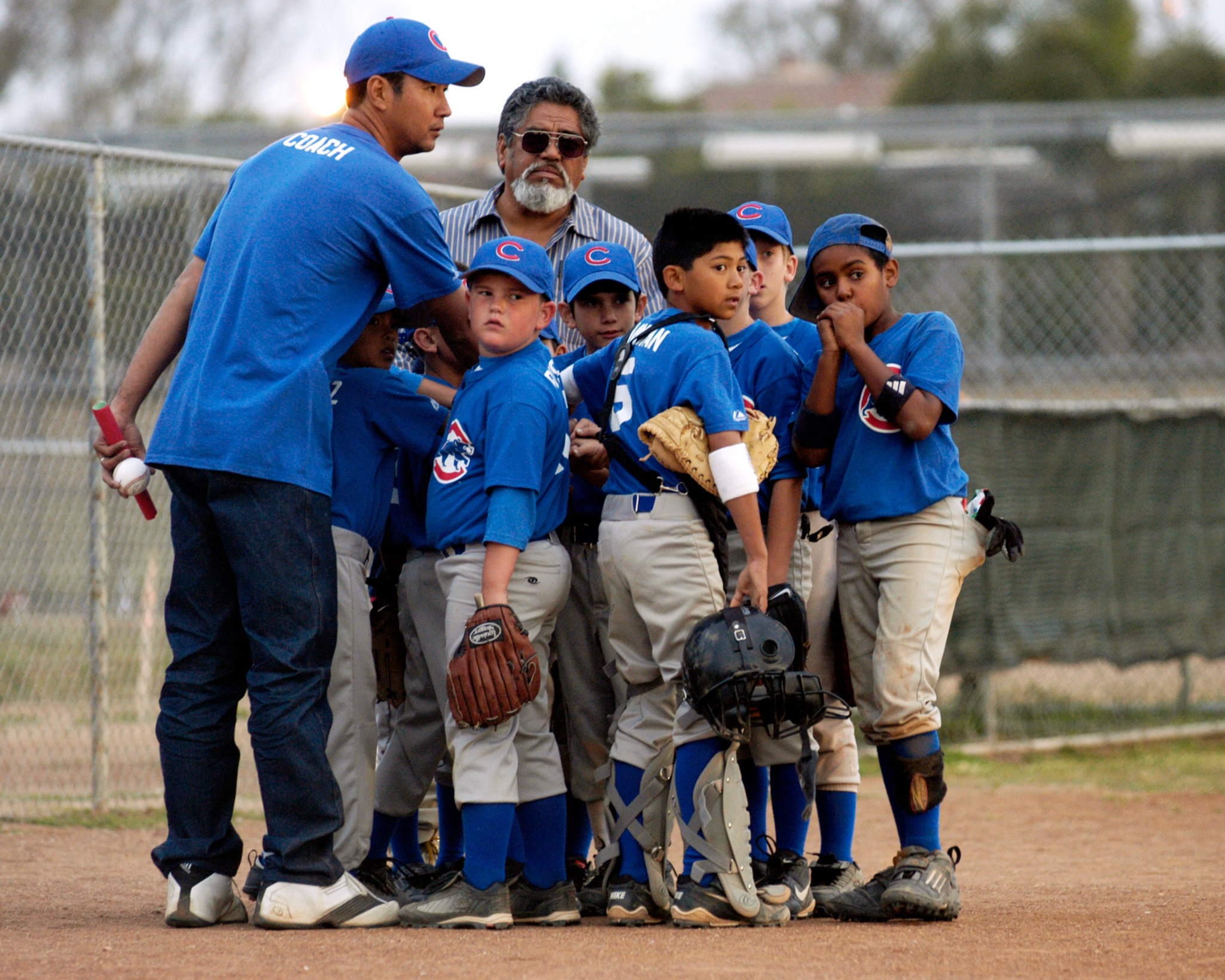 Youth baseball team gathered with coaches during the game