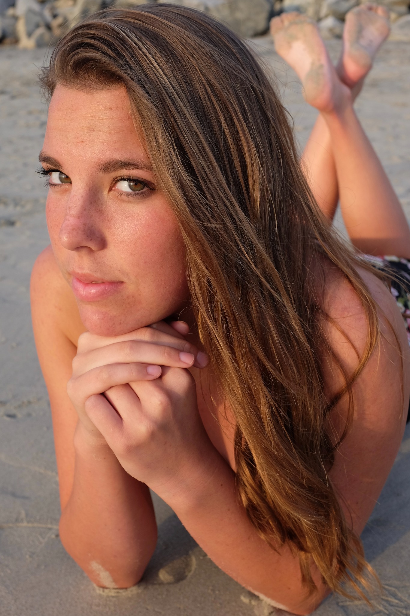 Portrait of a woman lying on the beach in warm light