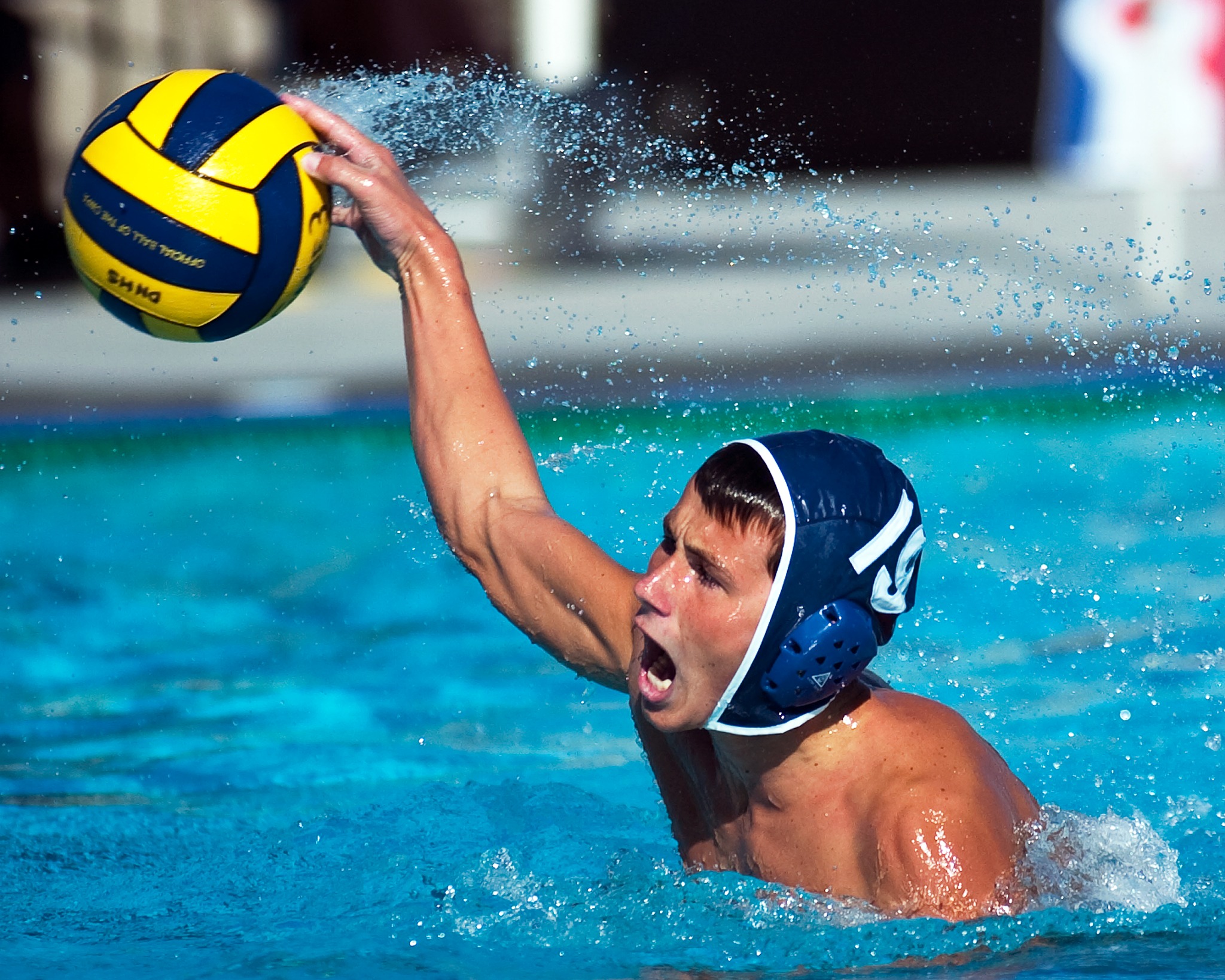 Water polo player rising from the pool with ball raised to shoot